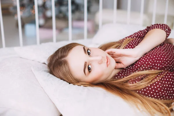 Meisje liggend op witte bed — Stockfoto