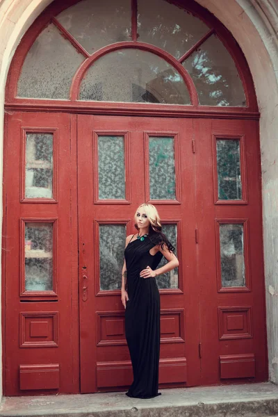 Blonde girl posing near old door — Stock Photo, Image