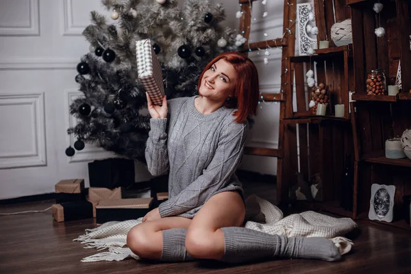 Frau sitzt neben Weihnachtsbaum — Stockfoto