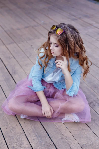 Κορίτσι στο ροζ φούστα κάθεται σε εξωτερικούς χώρους — Φωτογραφία Αρχείου
