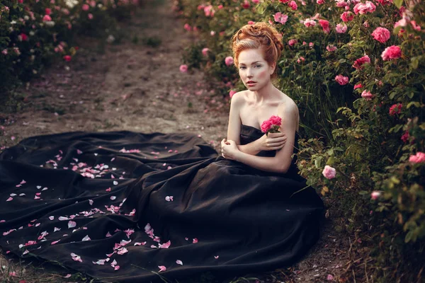 坐在靠近玫瑰的女人 — 图库照片