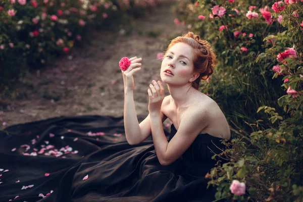 バラの近くに座っている女性 — ストック写真