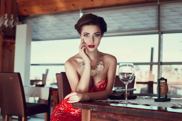 Vrouw in jurk poseren in restaurant — Stockfoto