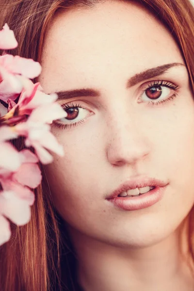 Brunette girl with pink flowers — Stock Photo, Image