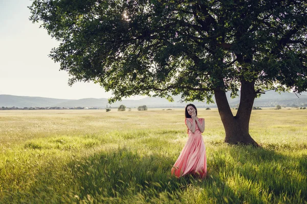 Kvinna i långa rosa klänning — Stockfoto