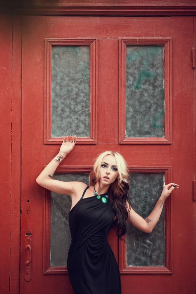 Chica rubia posando cerca de la puerta vieja —  Fotos de Stock