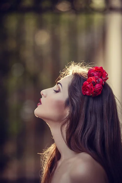 Mulher com flor vermelha no cabelo — Fotografia de Stock