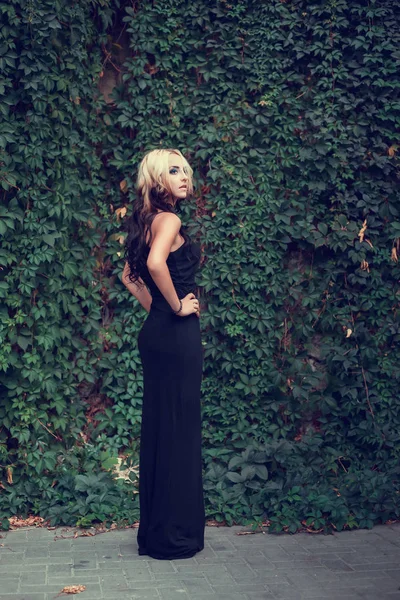 Vacker flicka i svart lång klänning — Stockfoto