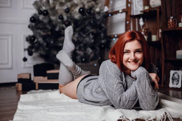 Mujer acostada junto al árbol de Navidad —  Fotos de Stock