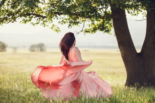 Vrouw in lang roze jurk — Stockfoto