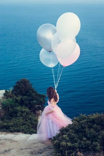 Vrouw in roze jurk met ballonnen — Stockfoto