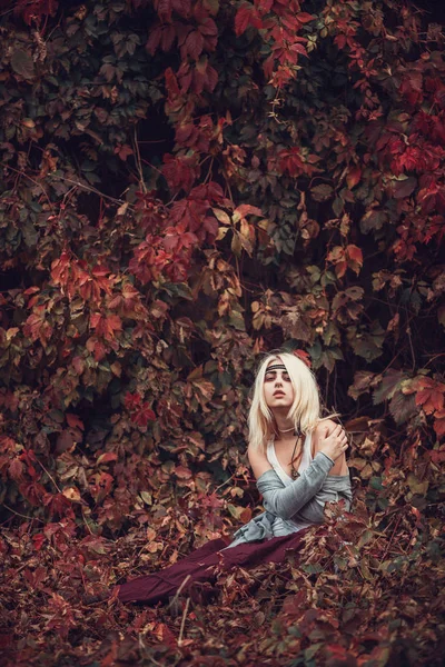 Ξανθιά κοπέλα ποζάρει στα κόκκινα φύλλα — Φωτογραφία Αρχείου
