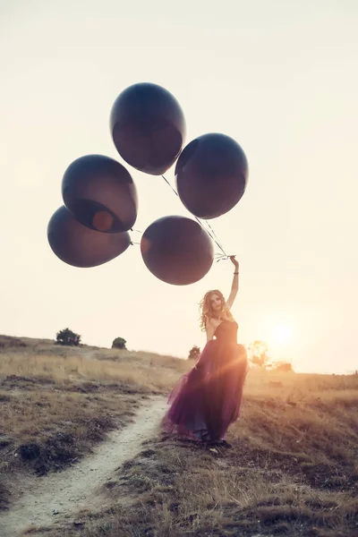 風船を持って闇のドレスを着た女性 — ストック写真