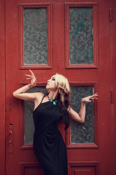 Blonde girl posing near old door — Stock Photo, Image