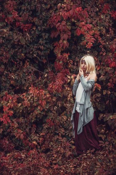 赤の葉でポーズ ブロンドの女の子 — ストック写真