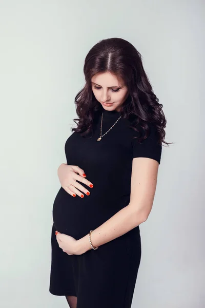 Wanita hamil berpose dalam gaun hitam — Stok Foto