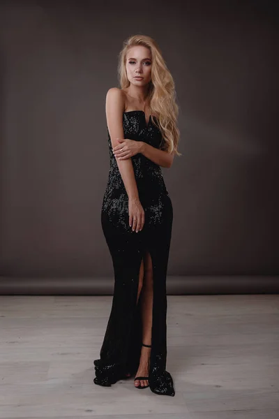 Vacker kvinna i svart klänning i studio — Stockfoto