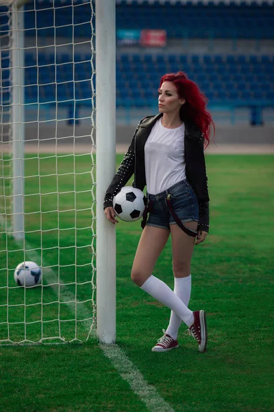 Mulher fitness sexy ou líder de torcida com uma bola de futebol — Fotografia de Stock