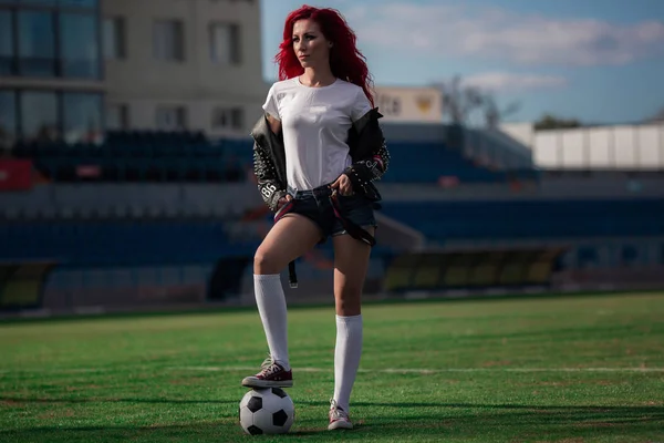 Mulher fitness sexy ou líder de torcida com uma bola de futebol — Fotografia de Stock