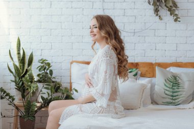 Young beautiful pregnant woman at home summer