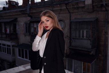 Güzel, genç, seksi bir kadın. Siyah, zarif ceketli, takım elbiseli, makyajlı, kırmızı rujlu çekici bir kız.