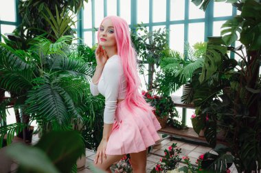 Güzel genç kadın kış bahçesinde poz veriyor..