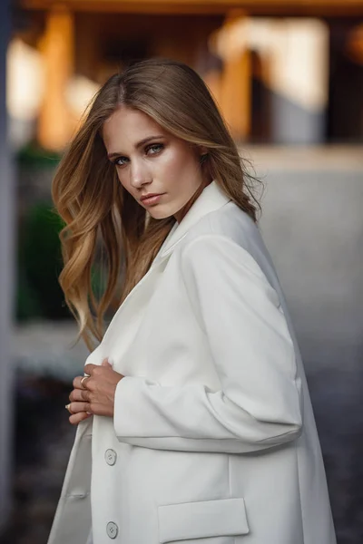 Outdoor full body fashion portrait of fashionable woman in white suit posing in street of east city — Stockfoto