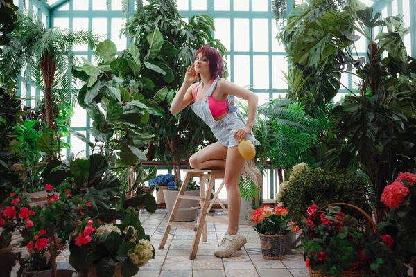 Beautiful young woman works in a greenhouse or in a closed conservatory. — 스톡 사진