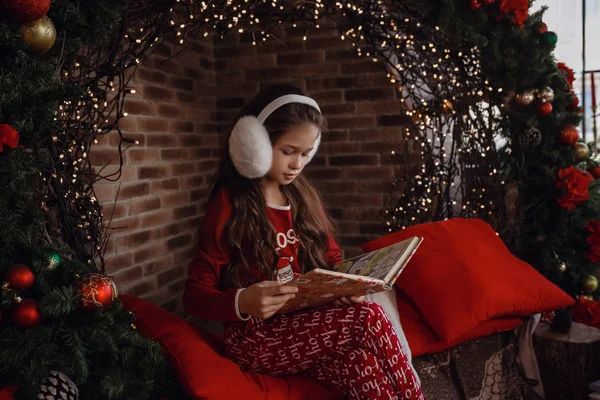 Hermosa niña en pijama rojo en la habitación en una mañana de Navidad —  Fotos de Stock