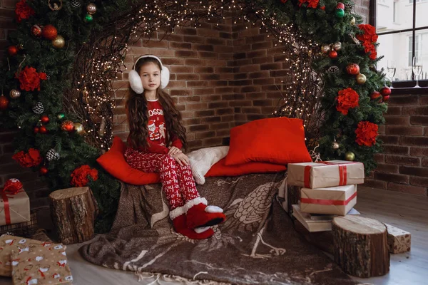 Красивая маленькая девочка в красной пижаме в комнате рождественским утром — стоковое фото