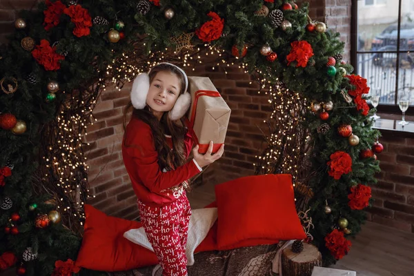 Hermosa niña en pijama rojo en la habitación en una mañana de Navidad —  Fotos de Stock