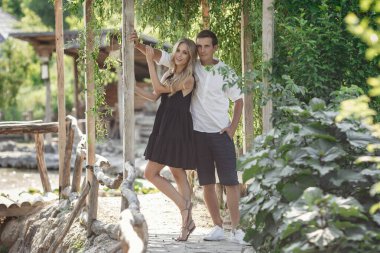 Young beautiful couple in the summer garden enjoys tranquility a