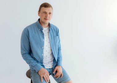 Young manly blond-haired man in a bright room.