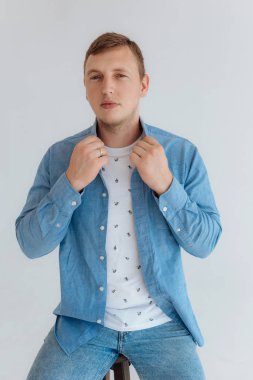 Young manly blond-haired man in a bright room.