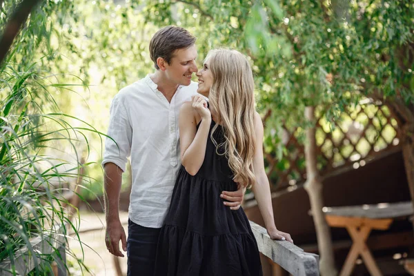 Young beautiful couple in the summer garden enjoys tranquility and relaxation — Stok fotoğraf