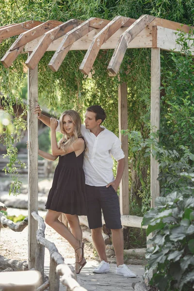 Young beautiful couple in the summer garden enjoys tranquility a — Stockfoto