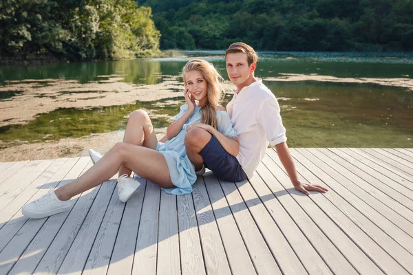 A szerelmesek élvezik egymást az esti tóban.. — Stock Fotó