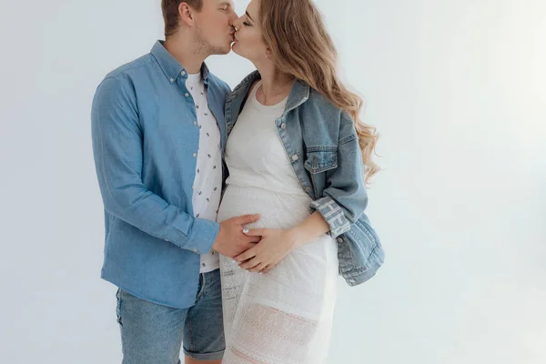 Shot of pretty young pregnant couple in the white room at home. — Stockfoto
