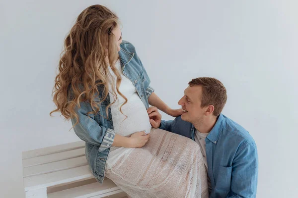 Foto de pareja embarazada bastante joven en la habitación blanca en casa . — Foto de Stock