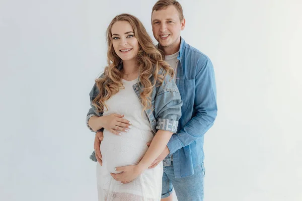 Shot van mooie jonge zwangere paar in de witte kamer thuis. — Stockfoto