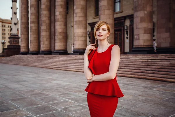 Elegant woman in long red dress and high heels, staying on stair — Stock Photo, Image