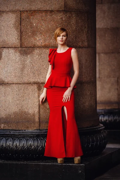 Mujer elegante en vestido rojo largo y tacones altos, permaneciendo en la escalera — Foto de Stock