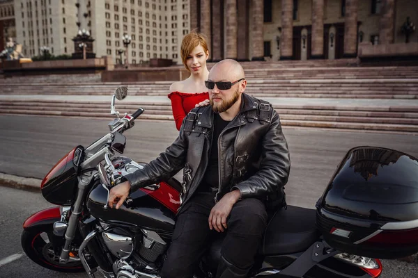 Mooi koppel op een coole motorfiets tegen Moskou — Stockfoto