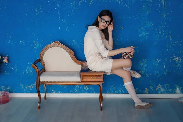 Ladylike woman in the pink dress is posing near the blue texture wall — Stock Photo, Image