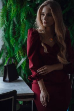 Elegant lady with glass of wine alone in restaurant