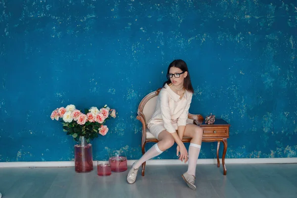 Ladylike woman in the pink dress is posing near the blue texture wall — 스톡 사진