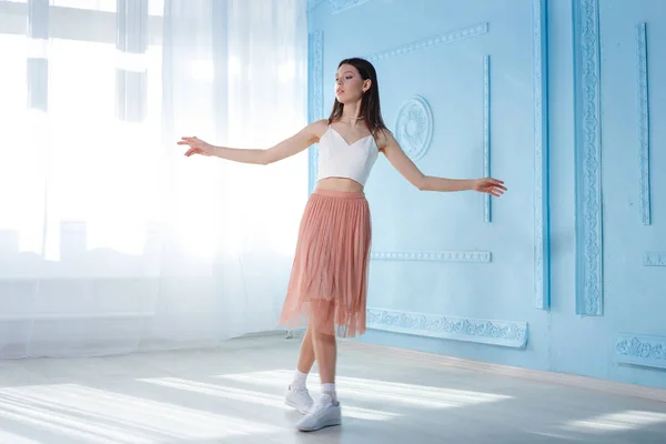 Full-length portrait of young woman dancing in studio. Indoor shot of slim stylish girl — 스톡 사진