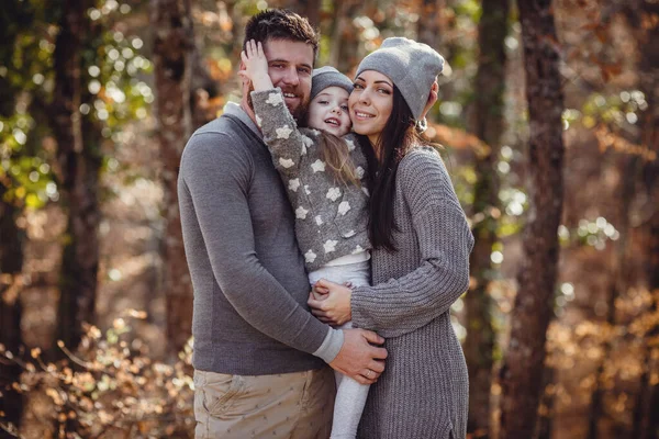Piękna młoda szczęśliwa rodzina w jesiennym lesie. — Zdjęcie stockowe