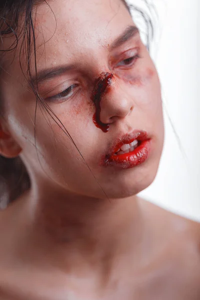 young woman with bruises on face victim of domestic violence. female fighter wearing bloody bandage on her fists, ready to fight. The idea of independence, feminism and defend their rights. Fight club