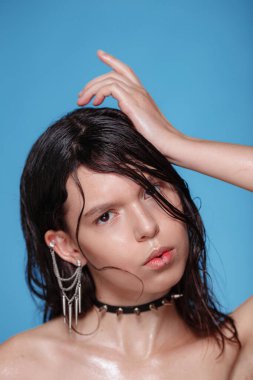 Arka planda piercingli ve diğer aksesuarları olan güzel bir kadının portresi. Duygusal bir yüz. Yüz ifadesi kavramı - kız başka tarafa bakıyor, şüpheli ve kararsız bir yüz ifadesi var..